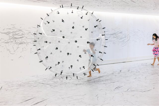 結合炭筆與大型漂浮球體的互動藝術展間